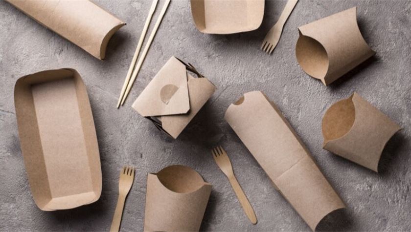 Assorted eco-friendly, biodegradable food containers and utensils for pho Vietnam made of brown paper, viewed from above.