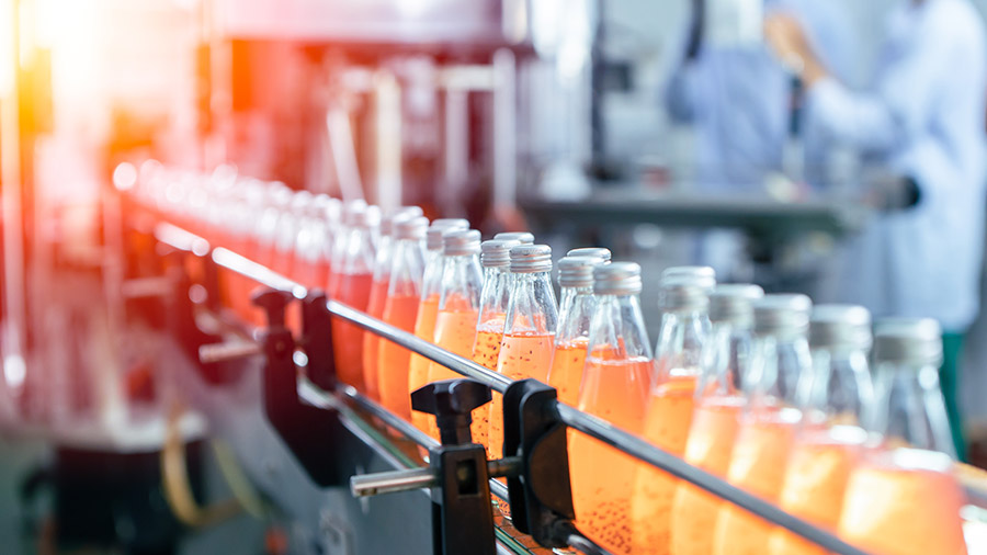 Production line with bottles of pho beverage in a Vietnam factory setting.