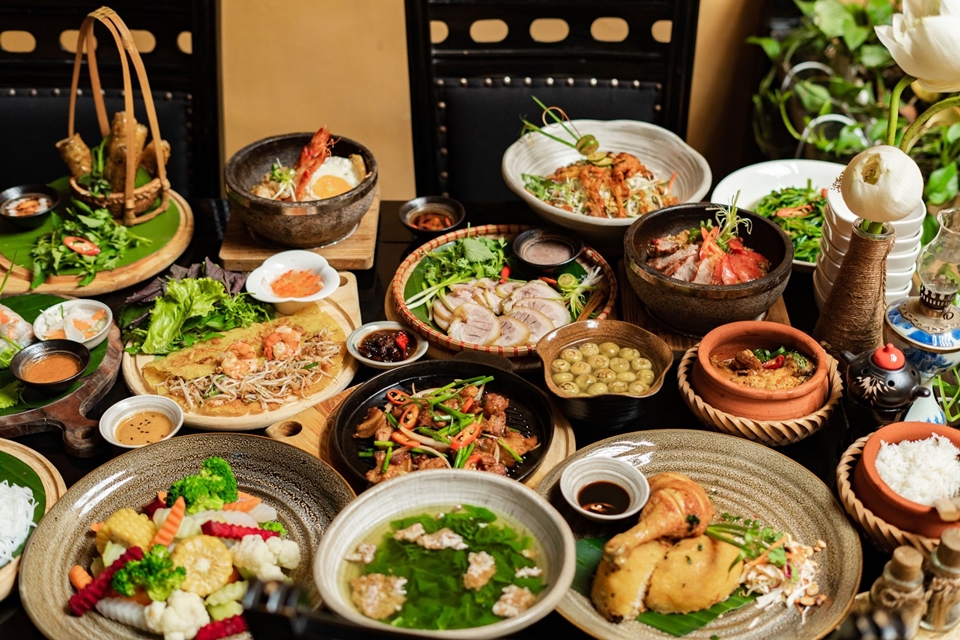 A sumptuous array of various Asian dishes, including pho from Vietnam, served on a traditional wooden table.