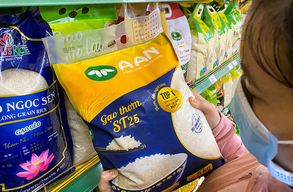 Person wearing a mask shopping for a bag of pho rice at a grocery store in Vietnam.