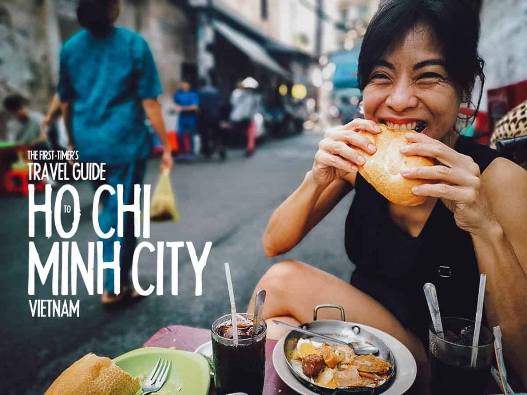 A woman enjoying a bowl of pho on a busy street in Vietnam.