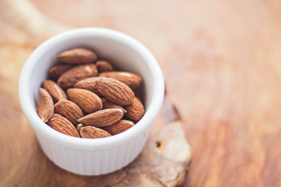 A bowl of almonds on a wooden surface reminiscent of Vietnam.