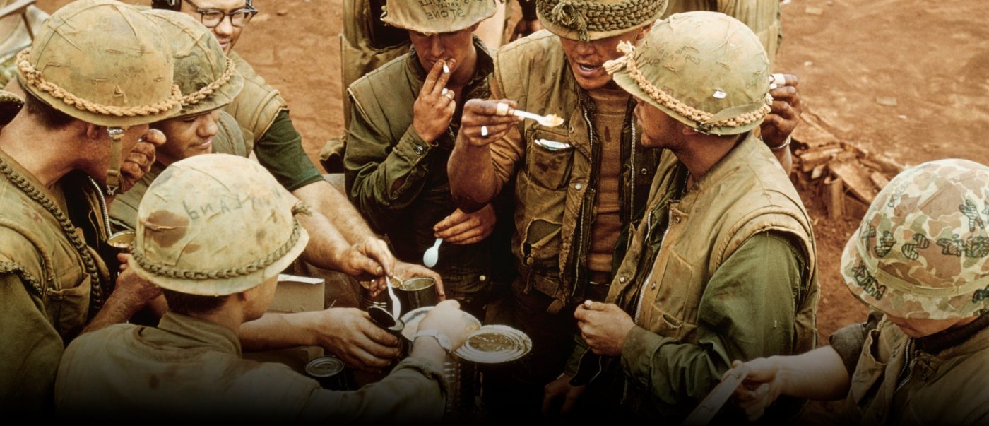 Group of soldiers sharing a meal of pho in a Vietnam field environment.