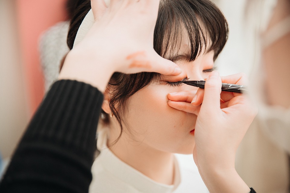 Makeup artist applying eyeliner to a woman's eyelids in Pho Vietnam.